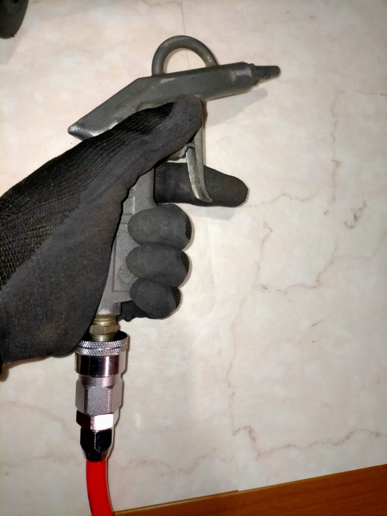 エアガンで真鍮製ジェットの細管内に詰まった白い粉を吹き飛ばして清掃。アネスト岩田 IS-925 レギュレーター部品の清掃に使用。エアブラシ用コンプレッサーのメンテナンスに必要な工具