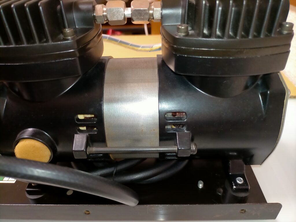 アネスト岩田 IS-925 オイルフリーミニコンプレッサーのメンテナンス・清掃完了後の本体側面（正面側）。エアレギュレーター・電源スイッチ・エアホース差込口・エアブラシホルダーを再組み付け後。シリコーンオイルで磨いた状態