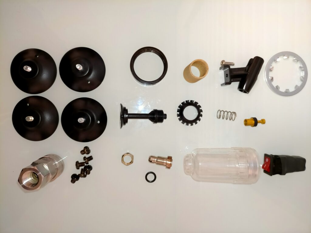 アネスト岩田 IS-925 ミニコンプレッサーの全分解部品の清掃完了後。エアレギュレーター・ガラスケース・モイスチャーフィルター・真鍮ジェット・ゴム足など全パーツが清掃済みで組み立て待ちの状態