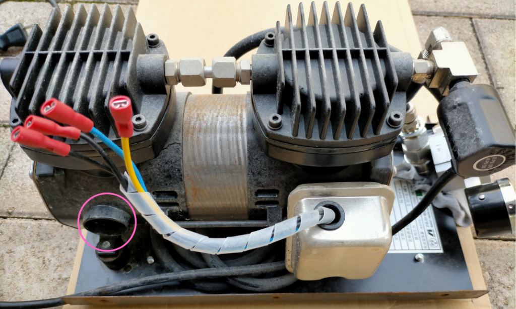 アネスト岩田 IS-925 エアフィルター欠損箇所を示した側面図。ピンク丸で示した吸気口のフィルターがなくなっており、粉塵を吸い込んでレギュレーター内に白い粉が堆積した原因と判明。フィルター交換が必要な箇所