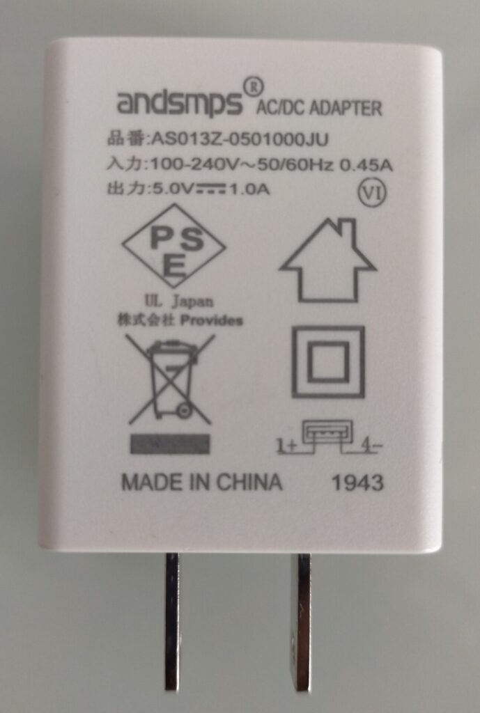 ルーペ（倍率30倍・望遠鏡の対物レンズ）でスマートフォン充電器の印刷文字「240V」を観察した画像。かろうじて「0」のカスレが見える程度でハッキリ確認できない。虫眼鏡2倍よりは見えるがKoolertron デジタル顕微鏡の鮮明度には遠く及ばない3種類比較