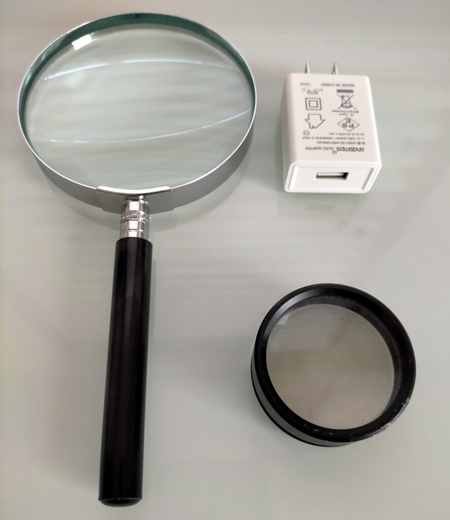 虫眼鏡（2倍）とルーペ（30倍・望遠鏡対物レンズ）でスマートフォン充電器の印刷文字「240V」を観察しているセットアップ。Koolertron デジタル顕微鏡との比較用。2種類の光学器具を並べた状態