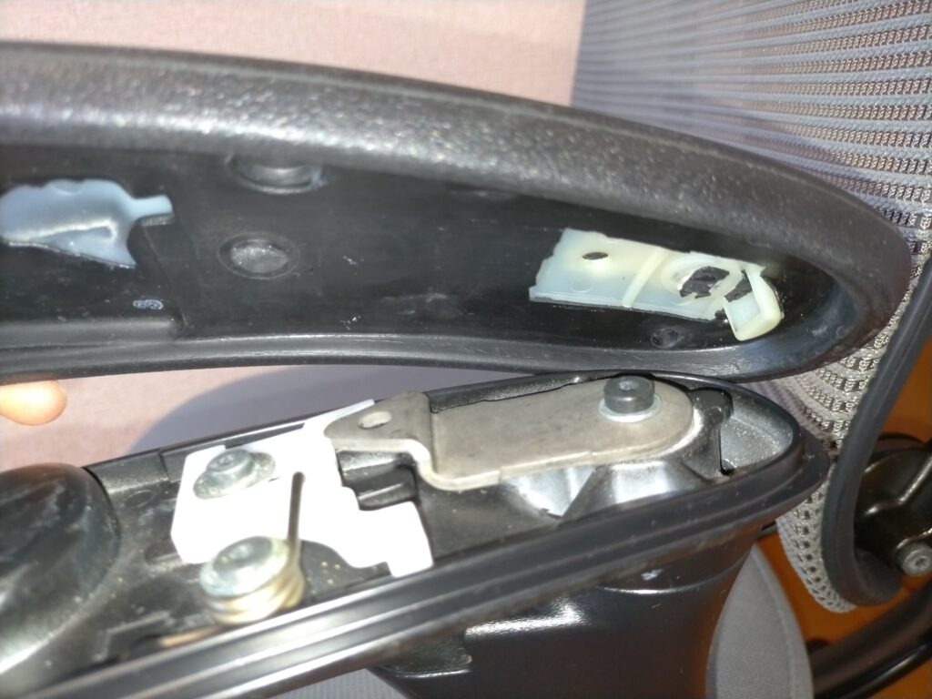 オカムラ コンテッサ肘パッド修理STEP1・裏面のビス2本をプラスドライバーで外し後ろにスライドさせて肘パッドを正しく取り外した状態。無理に持ち上げると内部の爪（フック）が折れるため必ず水平スライドで取り外すことが重要