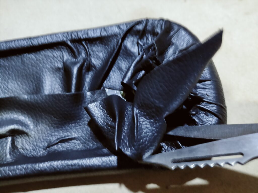 オカムラ コンテッサ肘パッド修理STEP7・貼り合わせ後に肘パッド外周からはみ出した余分な合皮はぎれをハサミでカットして形を整えている仕上げ作業。この後コンテッサ本体に取り付けて修理完成