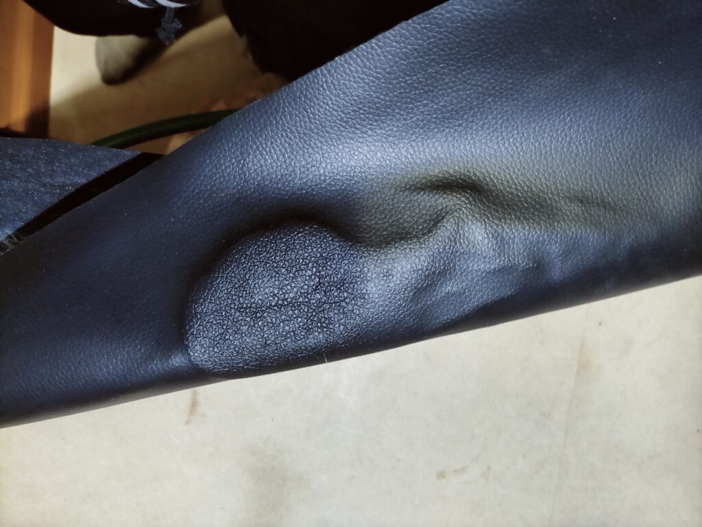 コニシボンドG10Zを塗布した合皮はぎれ（ダイソー製）に生じた接着剤による縮れ・シワの状態。合皮の種類によっては接着剤の影響で裏地が溶けたり表面が縮れることがあるが貼り合わせ時に伸ばしながら貼ると目立たなくなる