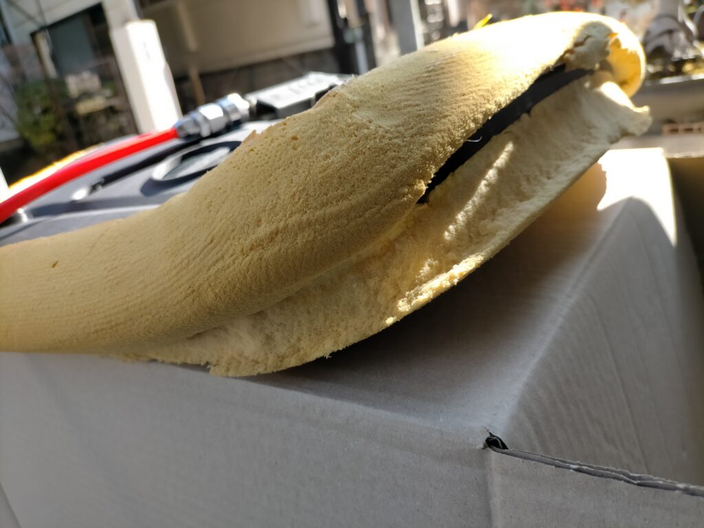 オカムラ コンテッサの座面ウレタンクッションの加水分解による亀裂・割れ目のクローズアップ。清掃・消臭後の接着修理前の状態。この割れ目にコニシボンドG10Zを塗布して20分乾燥後に圧着接着する