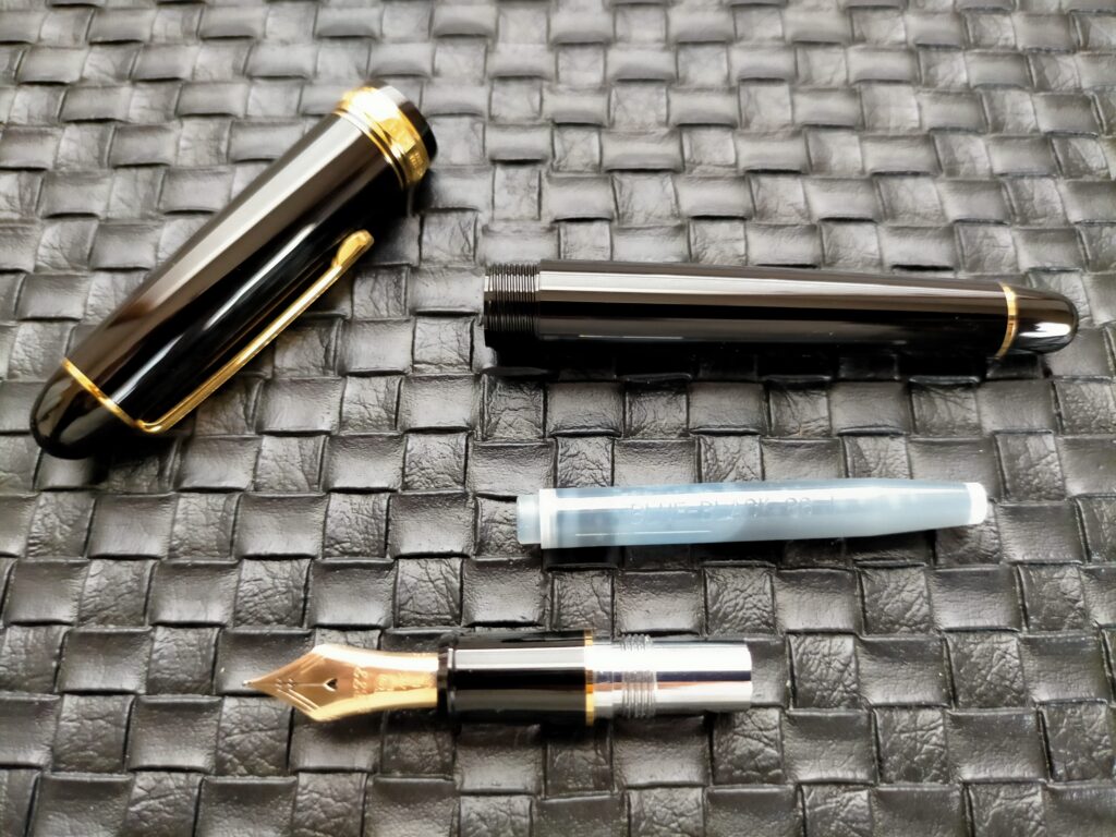 プラチナ万年筆#3776センチュリー M(中字)の分解写真。キャップ・軸・ペン先(14Kニブ)・カートリッジインクの各パーツを分離した状態。ペン先(ニブ)は富士山を二重に重ねたデザインで大型14Kゴールド製。カートリッジ交換式で手が汚れない。スリップシール機構はキャップ内部の気密構造で長期インク乾燥を防止する