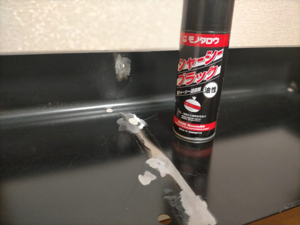 サンワ 100-KB004 取り付け作業Step5・塗装前。板金・バリ取り完了後の鉄板とシャーシブラック缶スプレー（自動車下回り用）を並べた状態。家族不在時に塗装推奨（強烈な臭いが数時間残る）。錆止め兼仕上げ塗装前