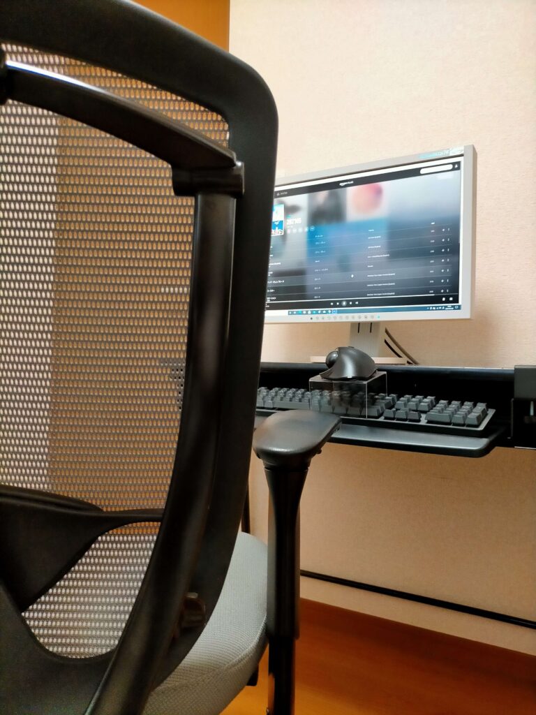 サンワ 100-KB004 キーボードスライダーを取り付けた机に、セリア「ディスプレイスタンドS」（100均・110円）をキーボード（ロジクール K840）上に跨がせてエレコム トラックボールマウス（M-XT2URBK）を乗せた完成状態。テンキー付きフルキーボードでもマウス置きスペースを確保した「神フィット」デスク環境