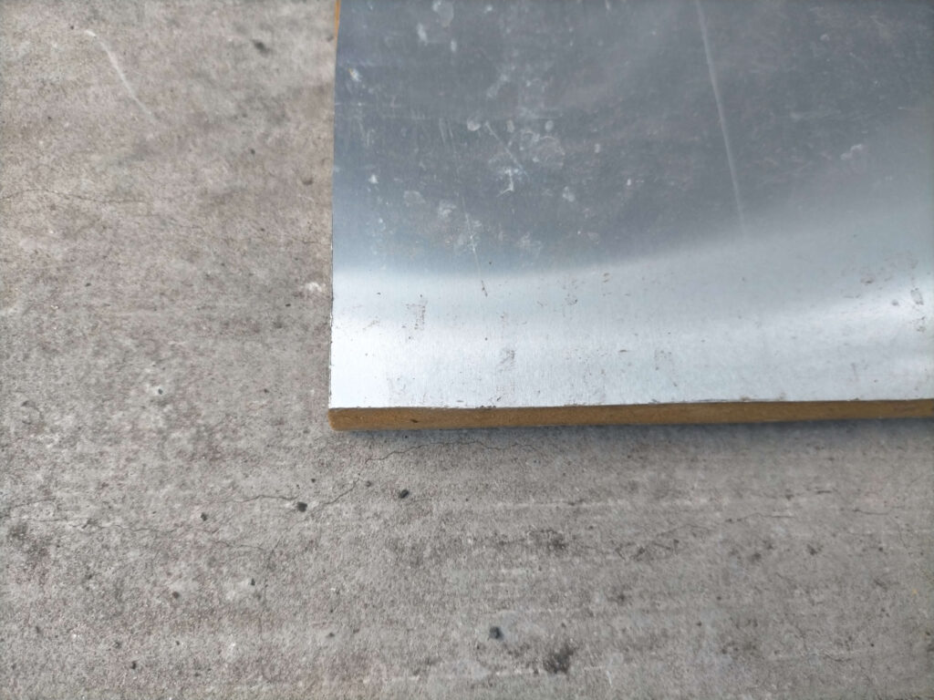GSメタルシートMS-2の上に敷く床材として使用した15mm MDFボードに0.5mm厚アルミ板を両面接着した仕上げ床材の上面写真。アルミ板貼りにより輻射熱反射と防湿効果を追加。車体形状に合わせて3枚に切り出した床板のうちの1枚。フロアタイル施工前の状態