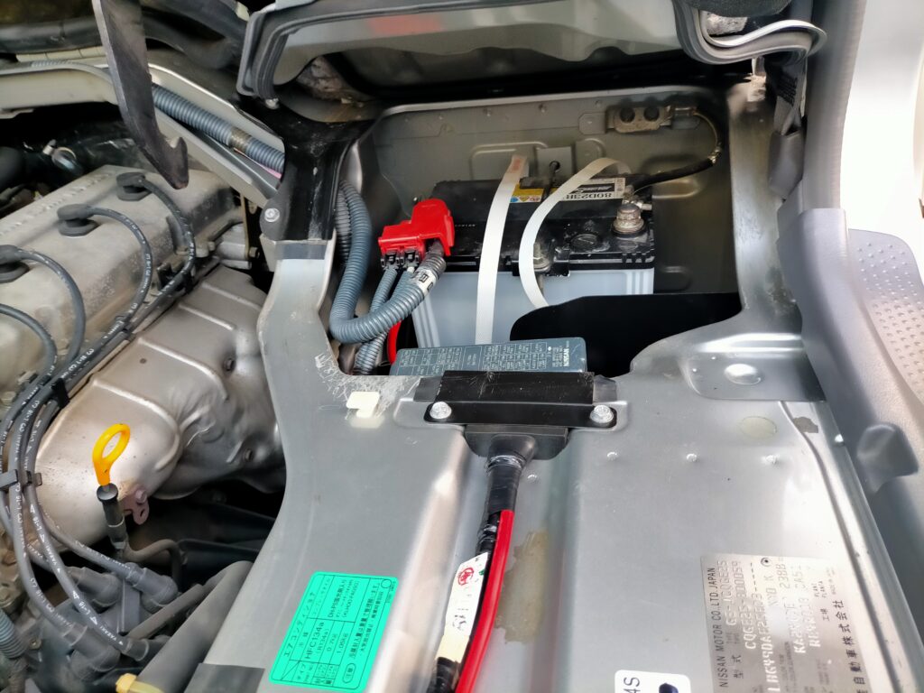 いすゞコモ（E25キャラバン）の作業前にショート防止のためバッテリーのマイナス端子を外した状態。