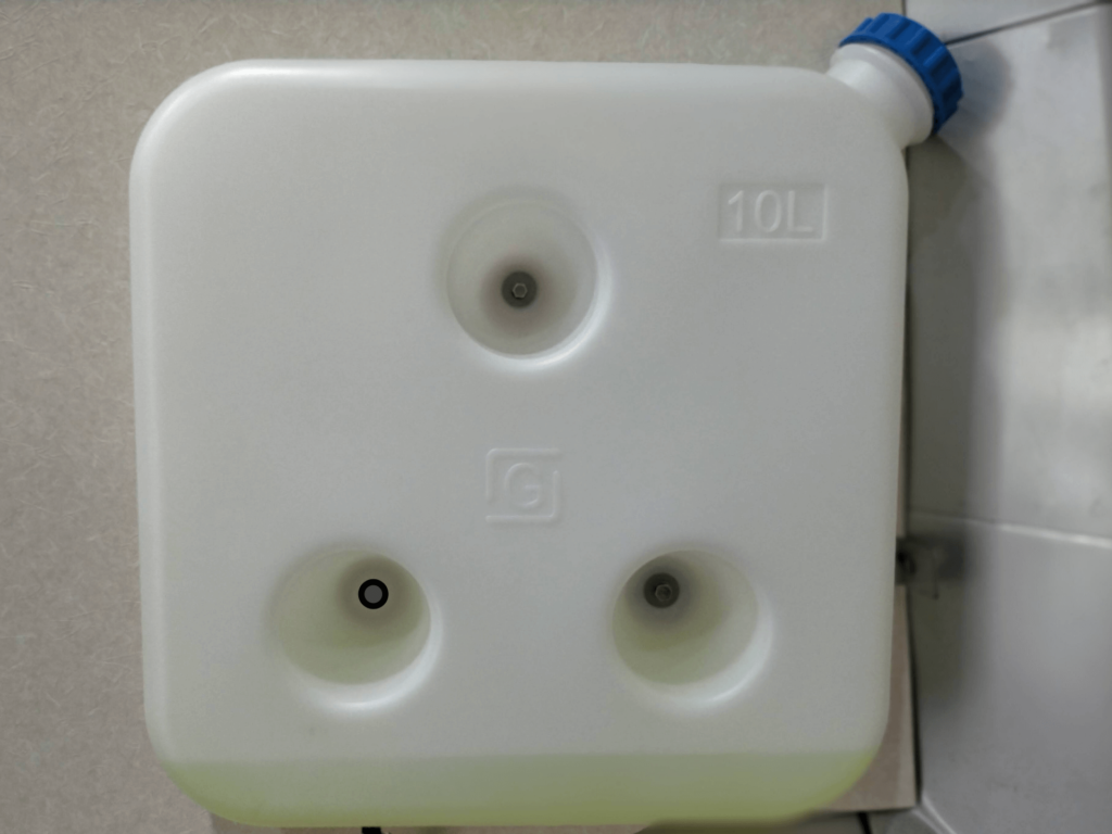 中華FFヒーター用10L燃料タンクを車体既存ナットと自作ステーを使用してボルト固定した完了状態。いすゞコモ(E25キャラバン)右リア給油口付近への取り付け。