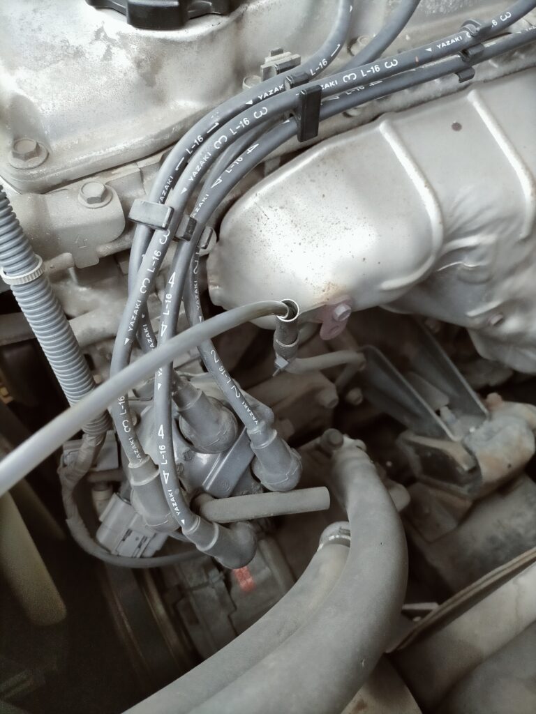 E25キャラバン／コモ（KA24DE）上抜きオイル交換ステップ2・12V電動オイルチェンジャー（AS-ee207）の吸入チューブをレベルゲージ差し込み口からオイルパン底部に向けて差し込んでいる工程。チューブは底まで差し込むことが重要。「ジュルジュル」音がするまで吸い出すのがコツ