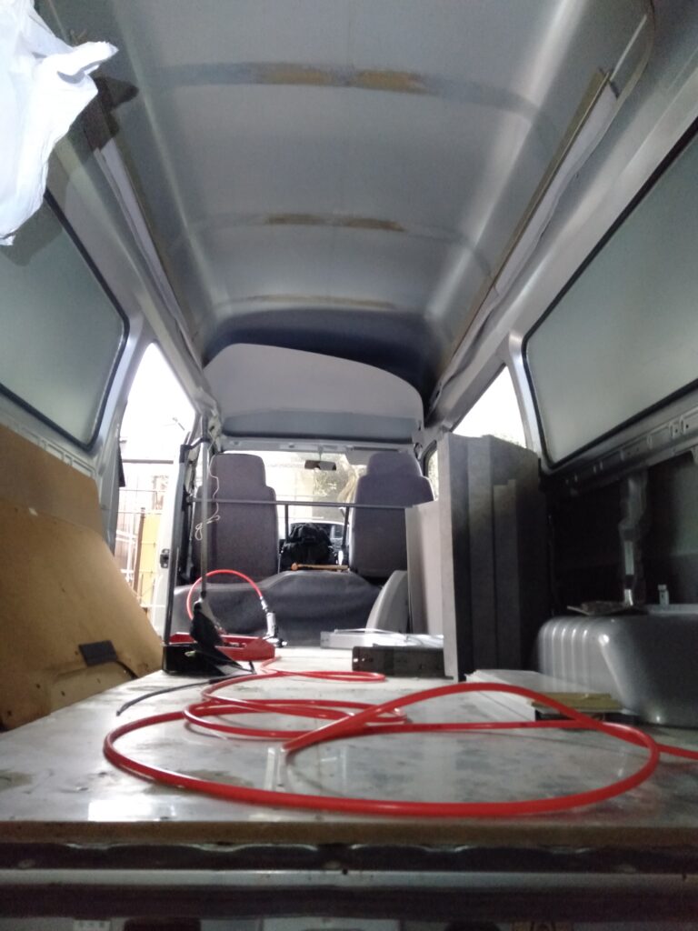 いすゞコモ（E25キャラバン）ハイルーフバンのルーフライニング（天井内張り）5枚を全て取り外した後の天井鉄板むき出し状態。シリコンオフで脱脂後にレジェトレックスD-300Nを叩いて「ビヨーン」と響く箇所を中心に全体の3〜5割程度に貼り付けるDIYステップ3の素地確認