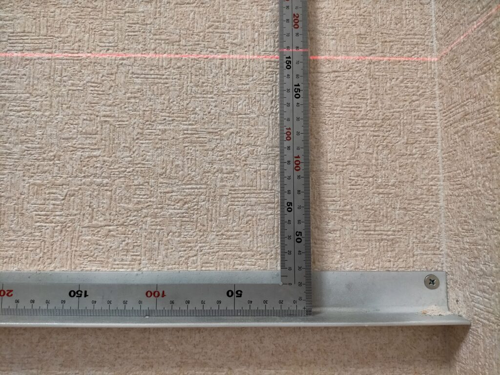 空中デスクDIYアングル取り付け工程・レーザー墨出し器のラインとアングルの水平を確認しながら全ビスを本締めしている工程。水平が出ていることを確認してから残りのコーススレッド4.8×75mmを全て本締め。水平精度がデスクの使いやすさと見た目を決定する