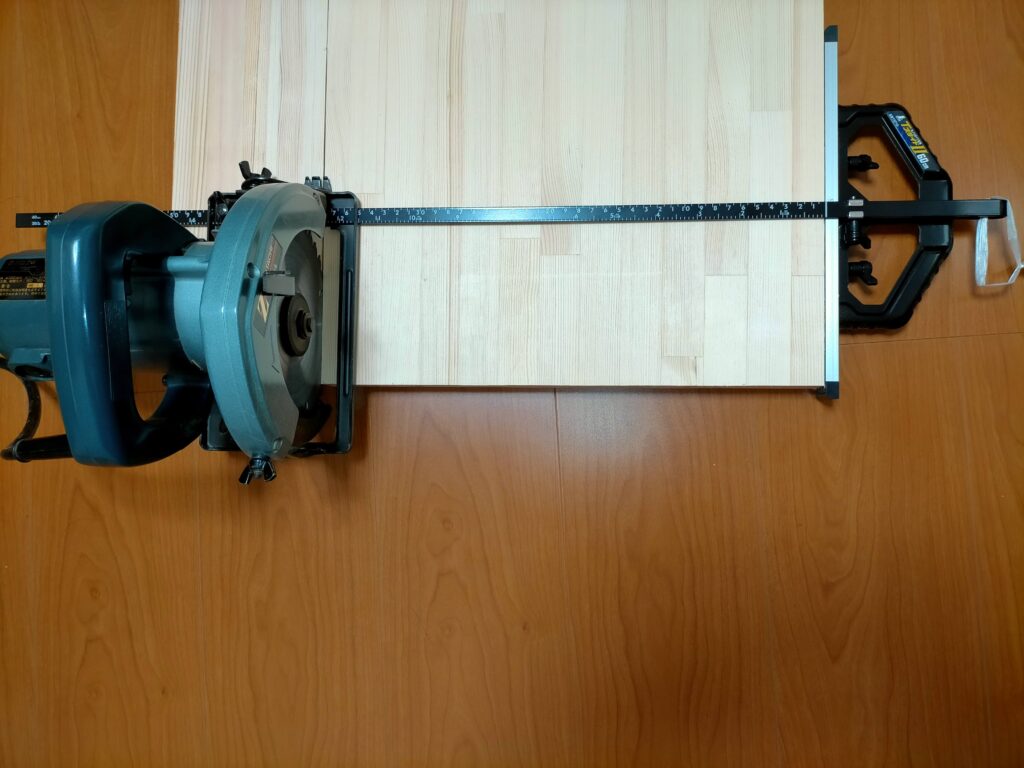 空中デスクDIY・L字サブデスク用に丸ノコガイド（Tスライド定規）を使って赤松集成材をサブ机の幅（1313mm）にカットしている工程。Tスライドガイドを使うことで丸ノコで集成材を直角かつ正確にカットできる。このカット材（1313×380mm）がL字デスクのサブ机天板になる