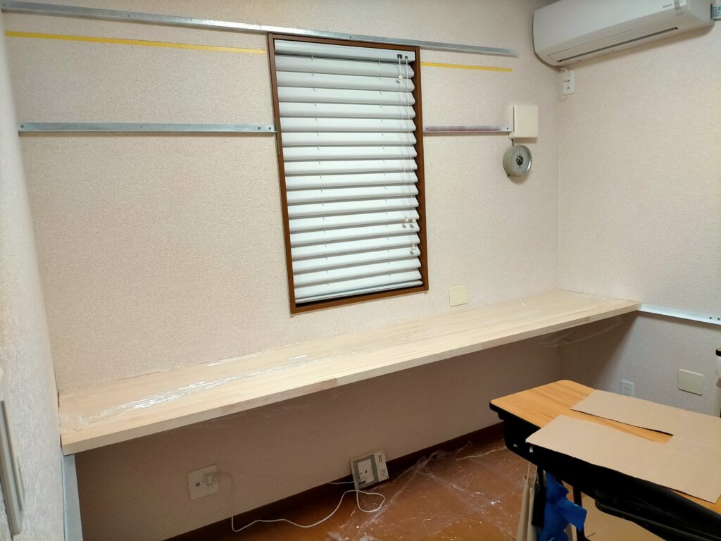 フローティングシェルフDIY・棚アングルと机アングルを仮置きして高さ・位置バランスを確認している工程。棚2段＋空中デスク（予算計2万円）を合わせた書斎DIY全体レイアウトの検討段階。脚なし浮き棚・浮き机の組み合わせで足元完全フリーを実現