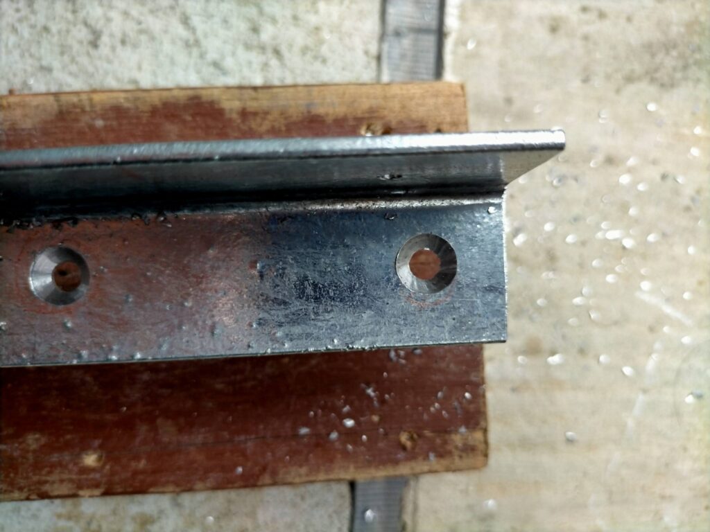 フローティングシェルフDIY・ドリルで開けたアングルの穴を面取り錐（皿取り錐）でさらう皿取り加工の工程。ビスの頭が板面・金属面からはみ出さず平ら（ツライチ）になるよう加工することで仕上がりが既製品品質に近づく