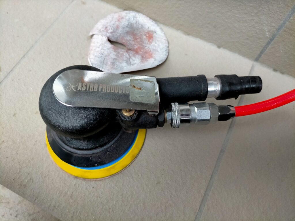 フローティングシェルフDIY・塗装前の下地処理工程。ダブルアクションエアーサンダーでアングル表面をアシズケ（足付け・研磨）して脱脂後にサーフェーサーを吹く準備。塗装密着力を高めるための必須下地処理。この後パールホワイトのラッカースプレーで仕上げ塗装