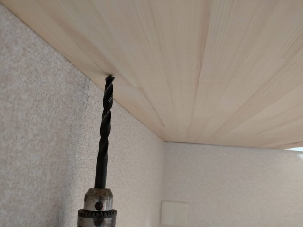 DIYザグリ穴隠しステップ1・10mmキリ（ドリルビット）で板面に垂直に深さ約10mmのザグリ穴をあけている工程。垂直を保つことがビス頭を正確に隠す前提条件。この穴にビス頭が収まることで板面からビスが飛び出さなくなる。5×80mmコーススレッドのビス頭径に合わせた10mm径