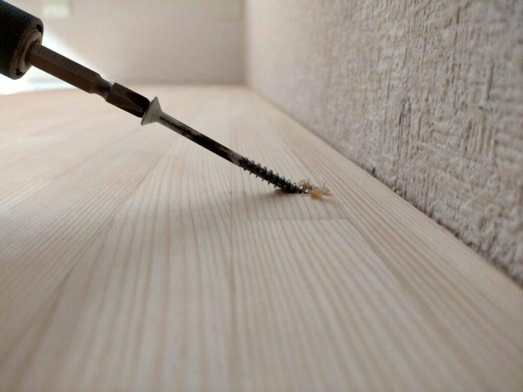 DIYザグリ穴隠しステップ3・5×80mmコーススレッドで板を固定した状態。ビス頭が10mmのザグリ穴の中に完全に収まり板面から飛び出していない状態。この後木ダボドリルΦ10で同一素材から木ダボを自作して穴を塞ぐことで表面が完全フラットな仕上がりになる