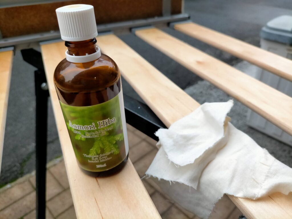 念には念を入れて青森ひば油（天然ヒノキチオール成分）原液をウエスに含ませてソファベッドMDF材に直接塗布している工程。施工当日はヒバの強い匂いがするが換気で数日で消える。スプレー処理に加えた原液塗布で長期抗菌効果を強化