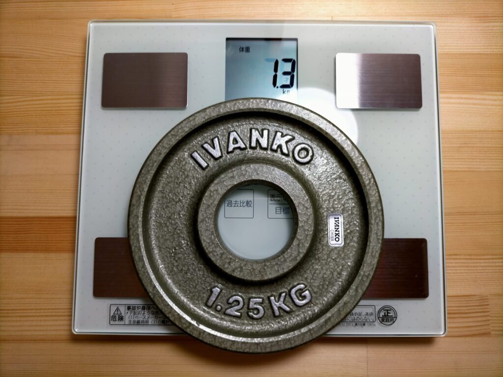 パナソニック体重計EW-FA13でIVANKOイヴァンコOMKオリンピックペイントプレート1.25kgを測定した結果1.3kg表示(分解能100gのため0.05kg単位での表示)。SF-890の1.258kg表示と比較してSF-890が刻印値に近い精度。重量精度±2%(±25g)以内