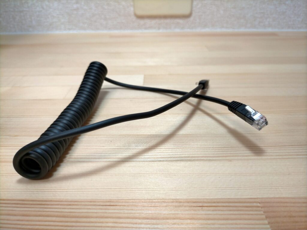 SF-890デジタル台はかりの計量皿と表示部をつなぐ接続ケーブルの端子部クローズアップ。見た目は電話線(モジュラーケーブル)に似ているが電話線ではなく専用コネクタ。隔測式デジタルスケールの特徴的な構造