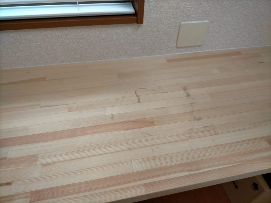 SF-890デジタル台はかりの計量皿裏のゴムが無垢材テーブルに黒い跡を付けた状態。掃除が大変なため無垢材・塗装なし木製家具の上に直置きする際は下に布や紙を敷くなどの対策が必要。購入時の重要な注意点として実証写真