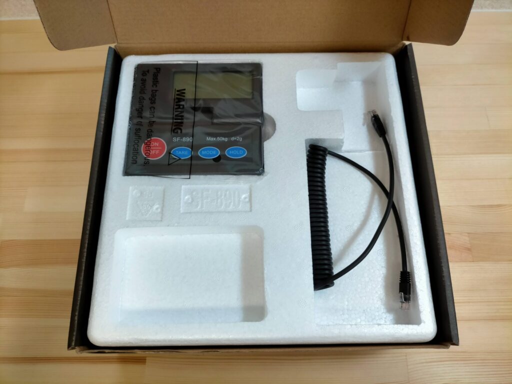 SF-890デジタル台はかりの開封内容物・表示部(ディスプレイ)と接続ケーブル。表示部サイズ116×118×19mm・文字高18mm。ケーブルは電話線に似ているが電話線ではない専用コネクタ。90度範囲で無段階角度調整可能な表示部