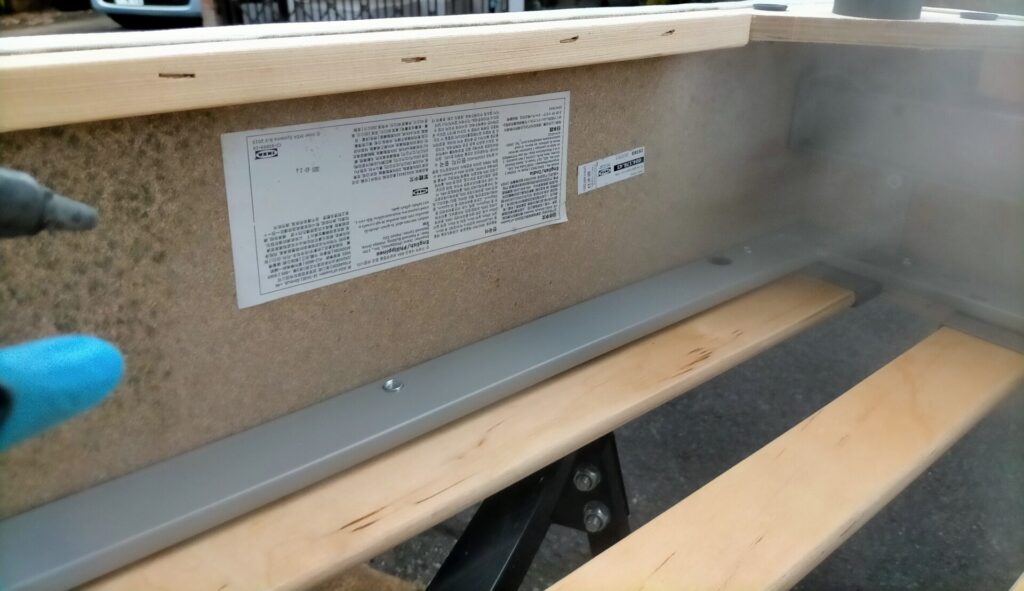 屋外でエアーブロアー（エアコンプレッサー）を使ってソファベッドMDF材のふわふわカビを吹き飛ばす除去工程。エアコンプレッサーなければ缶入りエアダスターでも代替可能。掃除機（室内にカビ胞子を拡散）・乾いた布拭き（カビを飛散）・濡れ雑巾（湿気付与）はNG