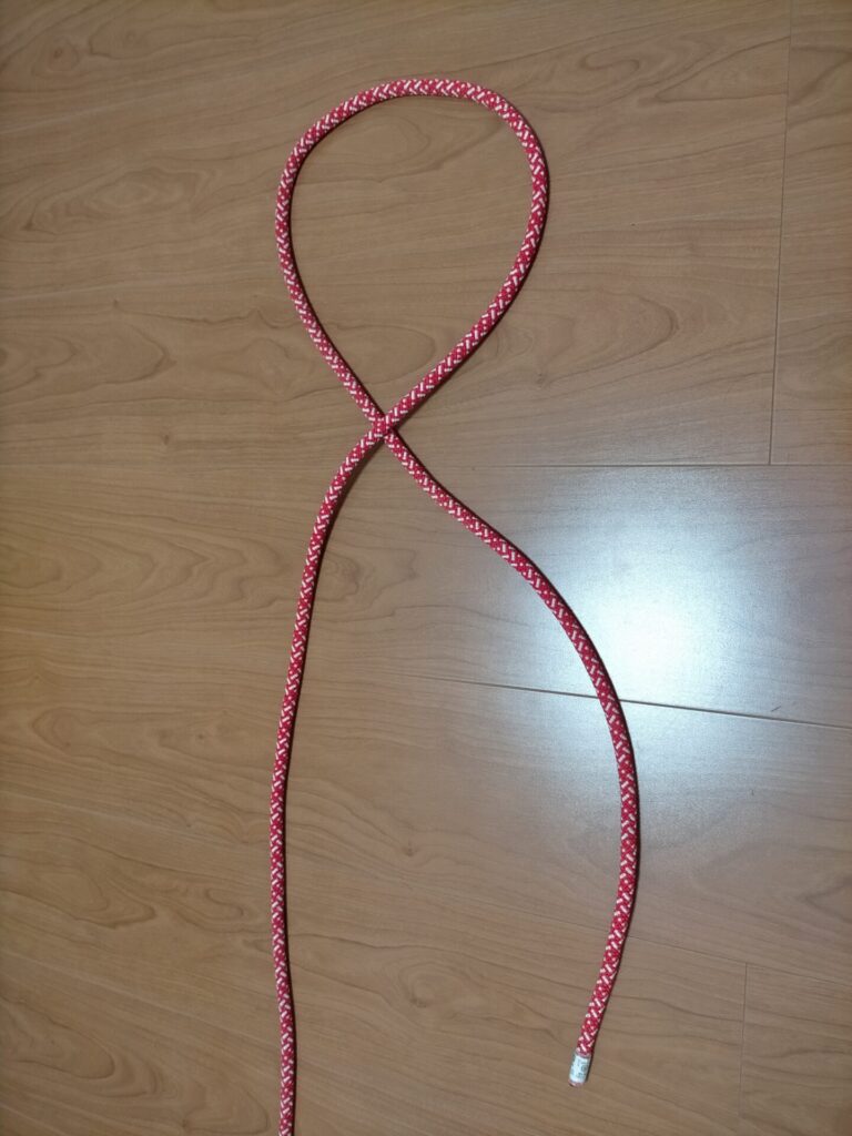 ダブルエイトノット(立木固定)の結び方手順1。まず1本のロープでエイトノット(8の字結び)の基本形を結ぶ工程。結び目は緩いままにしておく重要ポイント。ダブルエイトノットの第一段階