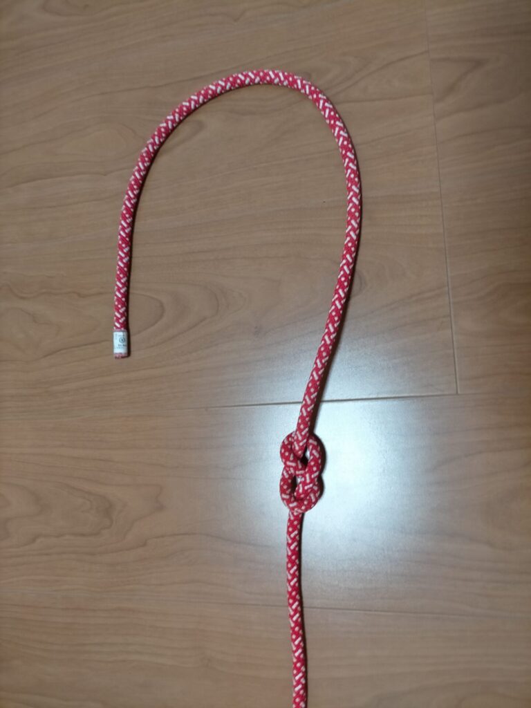 ダブルエイトノット(立木固定)の結び方手順4。エイトノット完成・結び目は緩いままの状態。ロープ先端を上の輪に通す準備。固定物に沿ってロープが通った状態を確認する工程