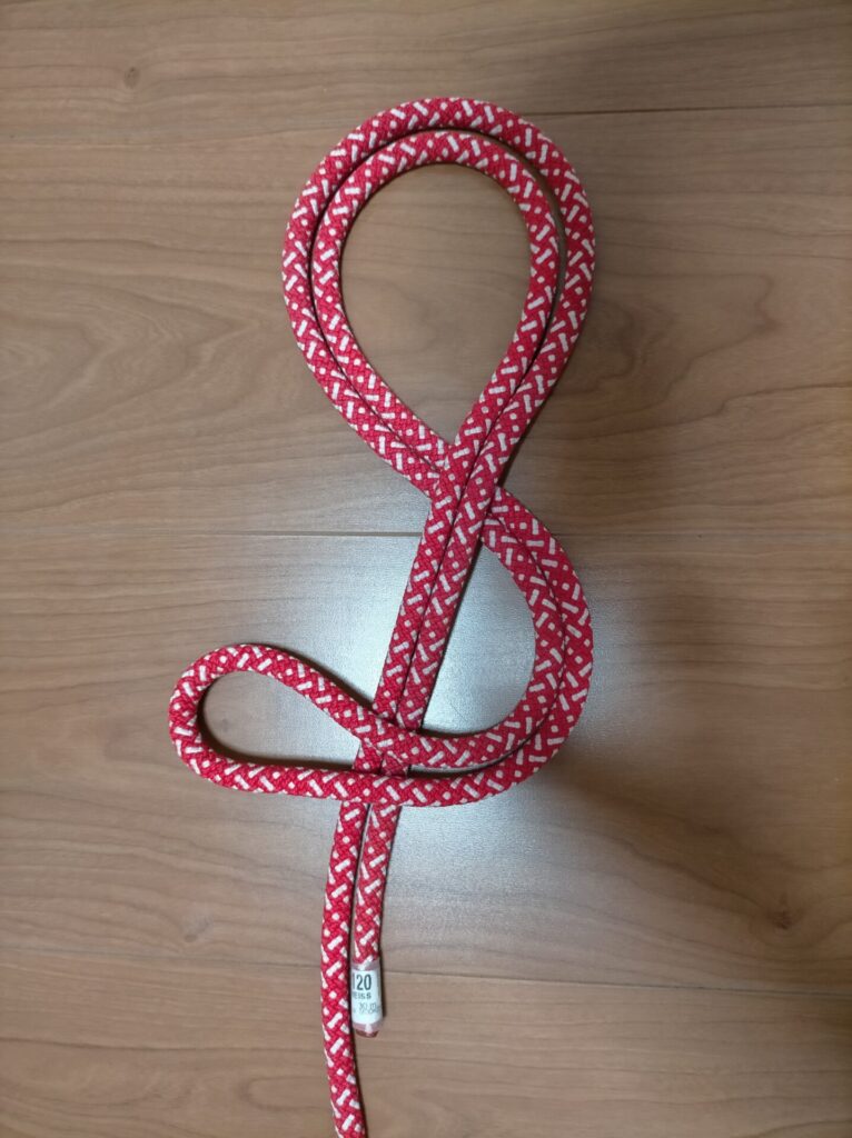 ダブルエイトノット(カラビナ用輪)の結び方手順2。8の字の輪を形成していく工程。ロープを折り返して輪に通す動作。DIY高所作業・外壁塗装の命綱用ロープワーク