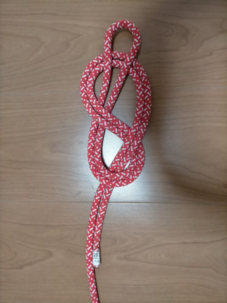 ダブルエイトノット(カラビナ用輪)の結び方手順3。8の字の輪を完成に近づける工程。ロープを引き通してカラビナ接続用の輪の形を整える動作。命綱結び方の重要工程