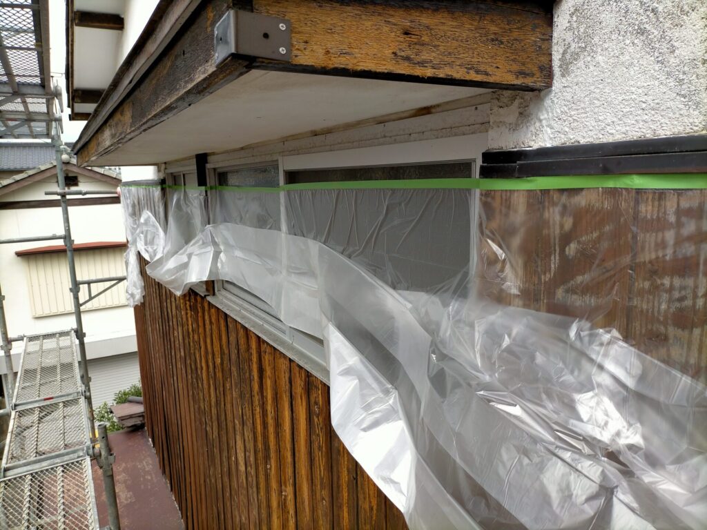 ひさし（庇）へのカンペハピオ水性カチオンシーラー乳白色下塗り作業。刷毛塗りで細部まで下地処理。ひさし・軒・棟木・母屋などの木部も含む軒下全体をカチオンシーラーで塗装してから上塗りへ進む手順