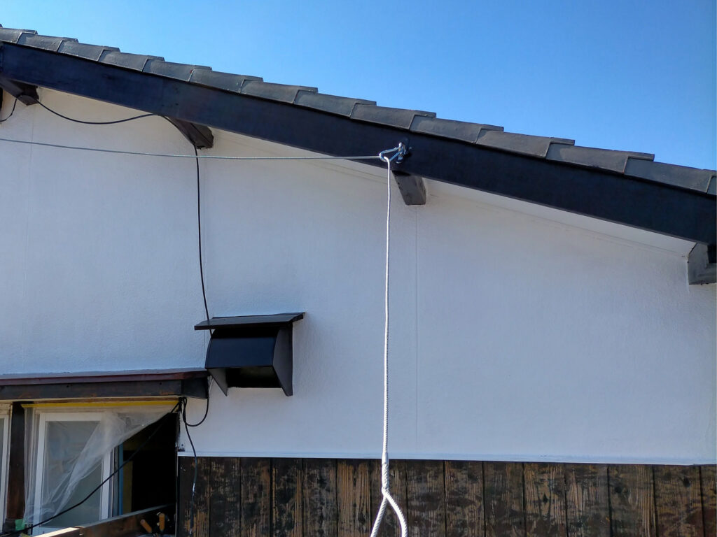 東面外壁DIY塗装の仕上がり図解。モルタル部に水性シリコン多用途（白）2回塗り・木部にこげちゃ1回塗り後の色分け配置図。カチオンシーラー下塗り→白2回→こげちゃ1回の工程順と塗り分け部位（モルタル・軒天・木部）を示した様子