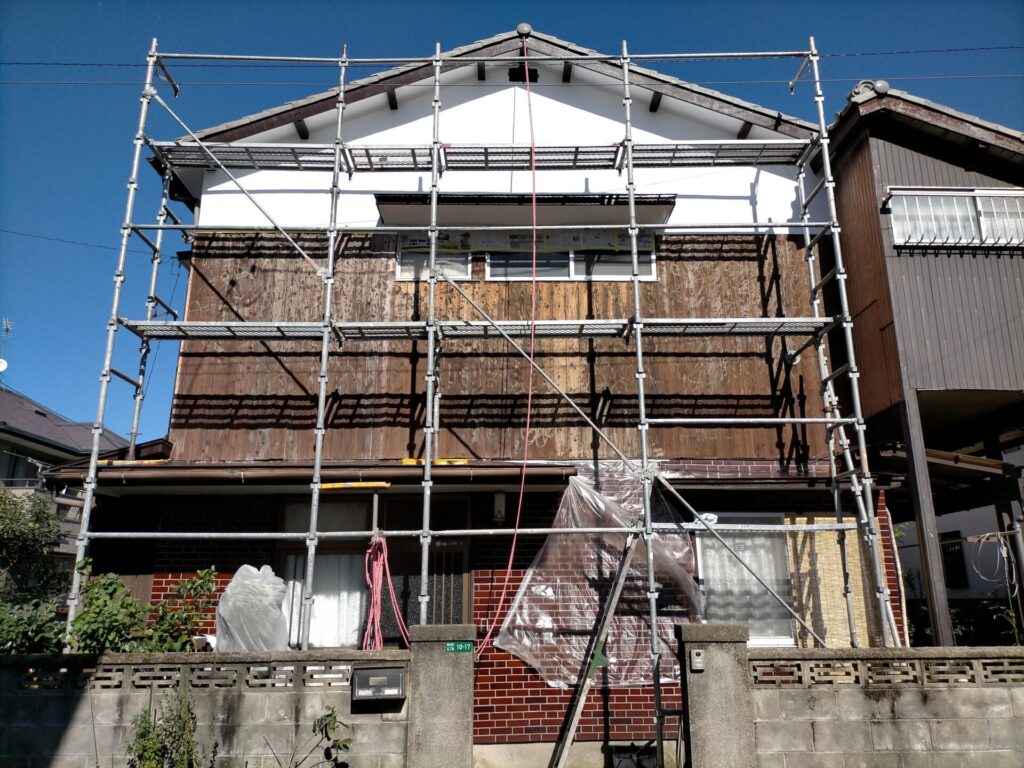 西面モルタル外壁・木部DIY塗装の完成状態。モルタル部へ水性シリコン多用途（白）2回塗り・木部へこげちゃ1回塗り後の仕上がり。チョーキングが出ていた旧塗膜をカチオンシーラー下塗り後にシリコン塗料で再生。白壁と茶の木部のコントラスト