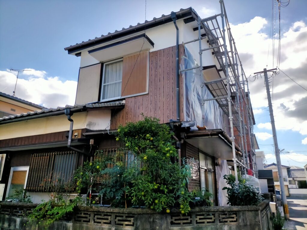 軒天ケイカル板シーリング後にカンペハピオ水性シリコン多用途（白）で外壁塗装と同時に上塗り仕上げしている工程。ケイカル板・軒・棟木・母屋・モルタル外壁を一括塗装。足場を最大活用する効率的な同時施工