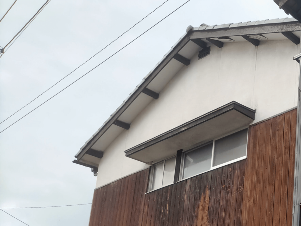 天修理DIYのビフォー状態・西面。くさび緊結式足場（77,000円）を設置して全面ケイカル板（6mm）重ね張りを実施した西面の修理前の劣化状況。東面より広範囲に軒天ベニヤの剥がれ・チョーキングが進行