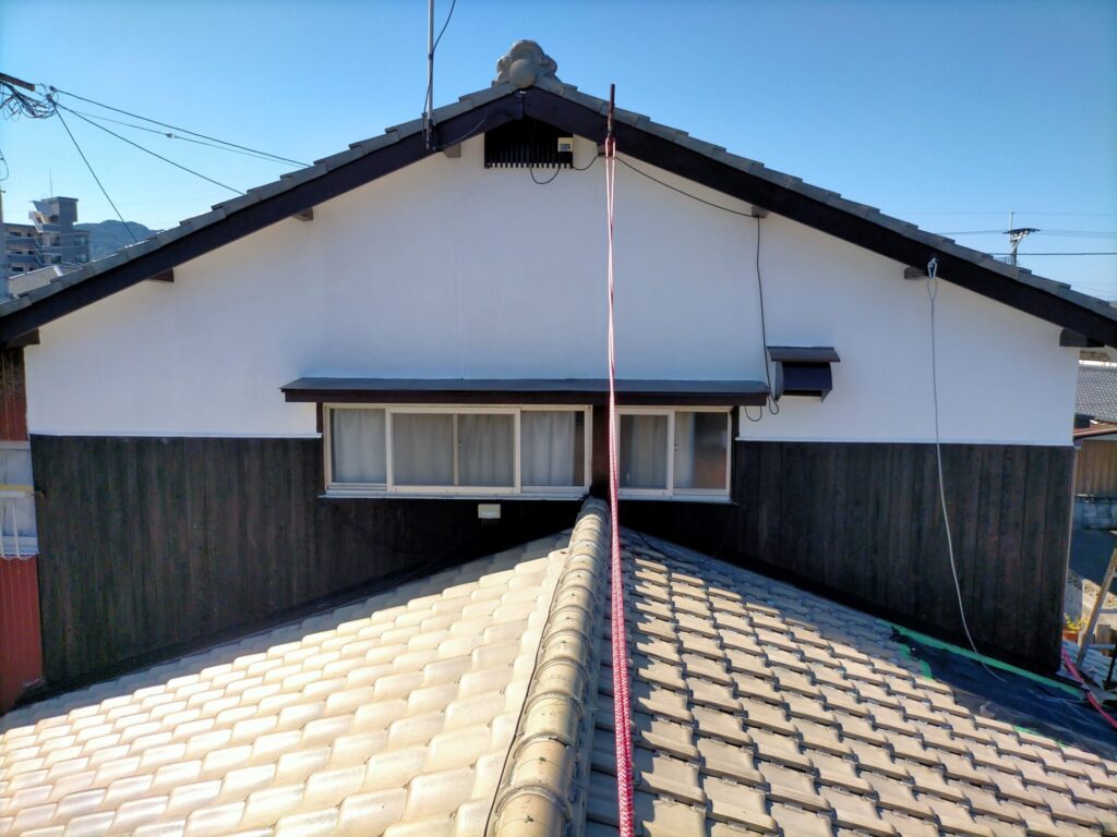 東面外壁焼杉板へのナフタデコール（ブラック）塗装完了・コーススレッド増し止め後の仕上がり状態。東面は足場なしで多機能はしごと安全帯（藤井電工ツヨロンTB-RN-590）のみで作業。塗装後の焼杉板とモルタル白壁の渋い色味