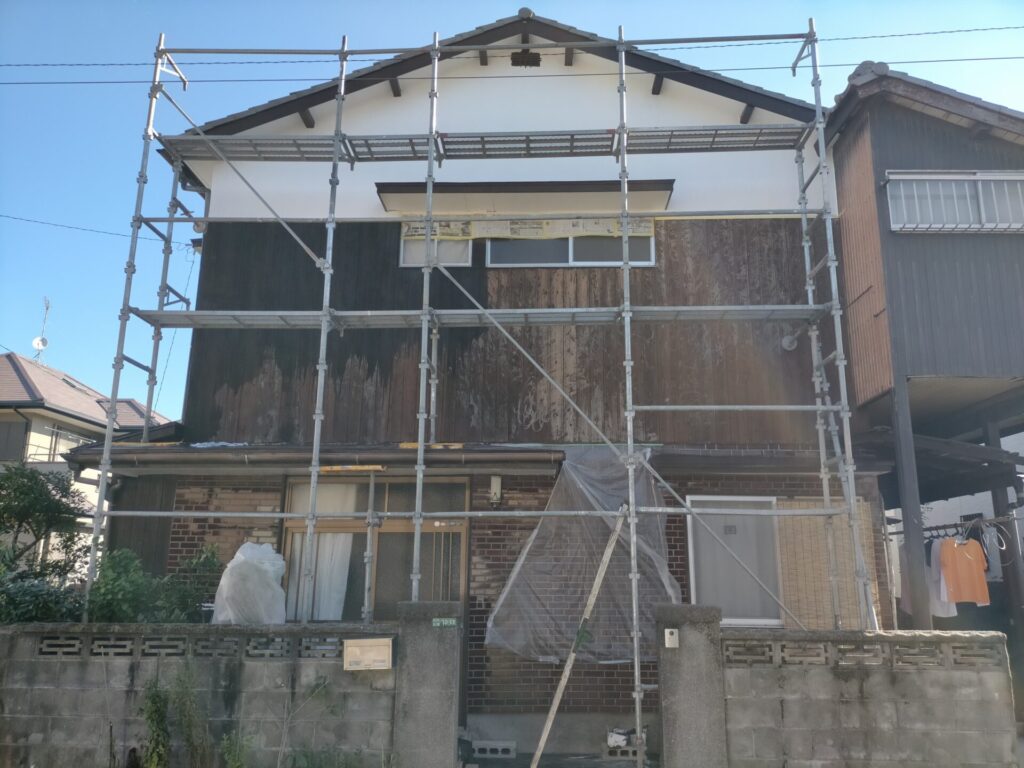 焼杉板外壁へのナフタデコール（ロックペイント・ブラック）塗装進行中の状態。コーワ防虫防腐剤用はけ平100mmを使用しハケにたっぷり含ませて塗布すると傷んだ焼杉板がぐんぐん吸い込む。万能刷毛50mmより作業効率が2倍向上