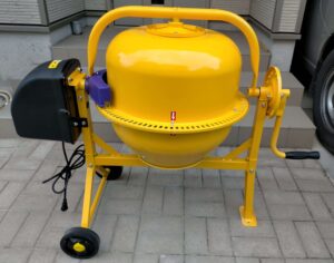 アルミス電動コンクリートミキサー「まぜ太郎」AMZ-30Y（約24kg・63Lタイプ）の全景。DIY土間打ち使用後の実際の状態でフリマアプリ出品時の撮影例として掲載。コンクリート汚れが付着しているが動作は良好