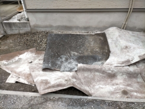 犬走りの石灰砕石を取り除いた後にデュポン ザバーン240防草シート（厚さ0.64mm）を剥がしている作業の様子。2019年4月施工から2年半後も繊維にコシが残り良好な状態