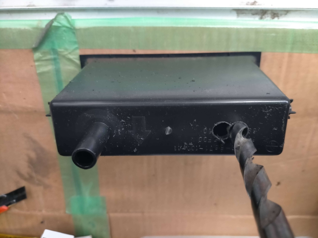 E25キャラバン/いすゞコモの1DINポケット（小物入れ）裏面にETC配線を通すためΦ10mmドリルで2箇所穴あけした状態。ETC本体をポケット内に隠す埋め込み取り付けのための加工工程①