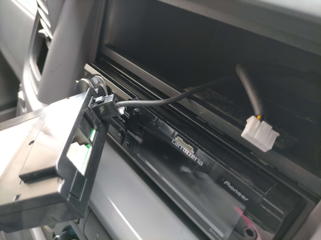 1DINポケット内に収めたETC2.0車載器DIU-C010に電源コネクタとアンテナコネクタを接続した状態。この後マジックテープで本体を固定してオーディオ・パネル類を元通りに組み戻す