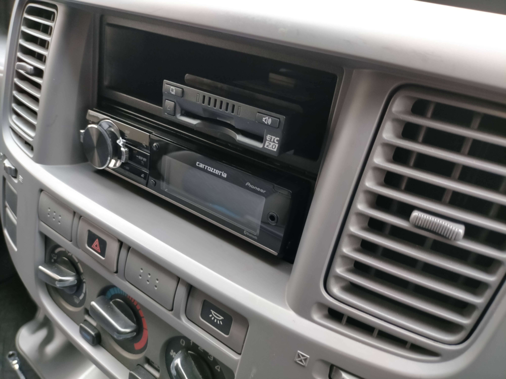 1DINポケット内にETC2.0車載器DIU-C010を両面テープ付きマジックテープで着脱可能に固定した状態。再セットアップ時や取り出しが必要な場合に備えた固定方法。この後パネル類を組み戻して取り付け完了