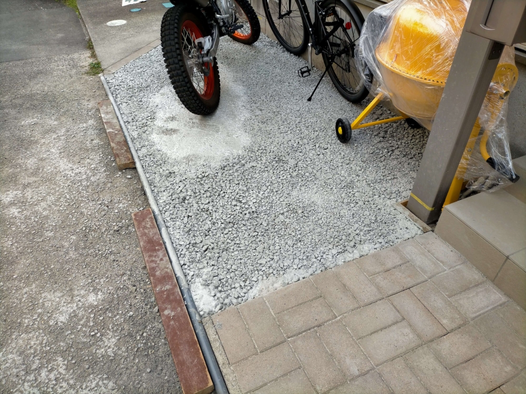 ポーラスコンクリート打設から1週間後の養生完了状態。中央部は十分な強度に達しバイクスタンドにも耐えられる。端部の表層剥離箇所はナルシルバーで補修済み。全体的にDIYバイク置き場として実用可能な仕上がり