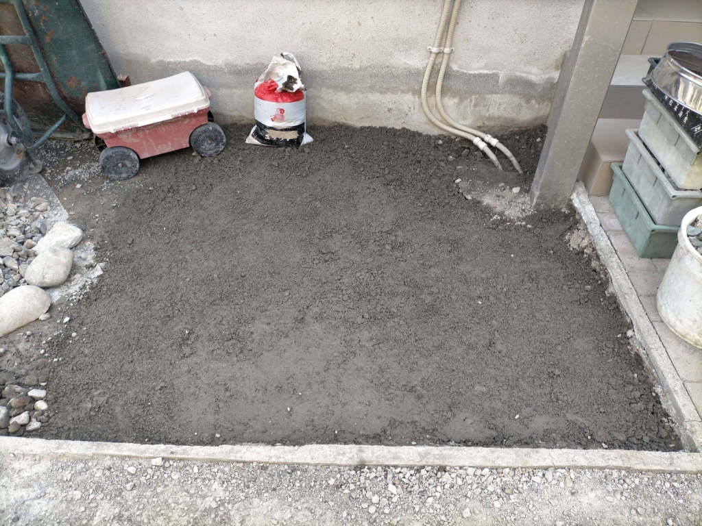 ポーラスコンクリート打設エリア（約5平米）の右半分の整地が完了した状態。深さ8cmの掘削・ふるい作業・砕石転圧が済み型枠設置・コンクリート打設が可能になった段階