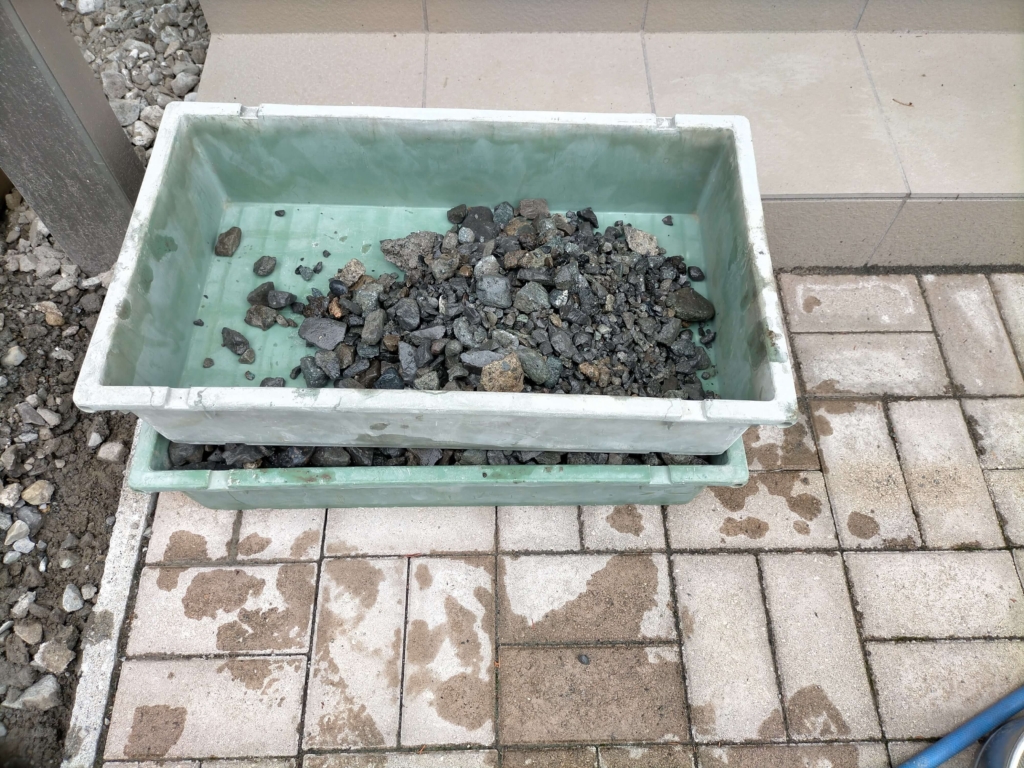 残土をふるいにかけて取り出した再利用砕石（4号相当・20〜30mm程度）の堆積。敷地内採掘で購入コスト0円を実現。建材屋で購入する場合0.5立米（約800kg）7,000円〜が目安